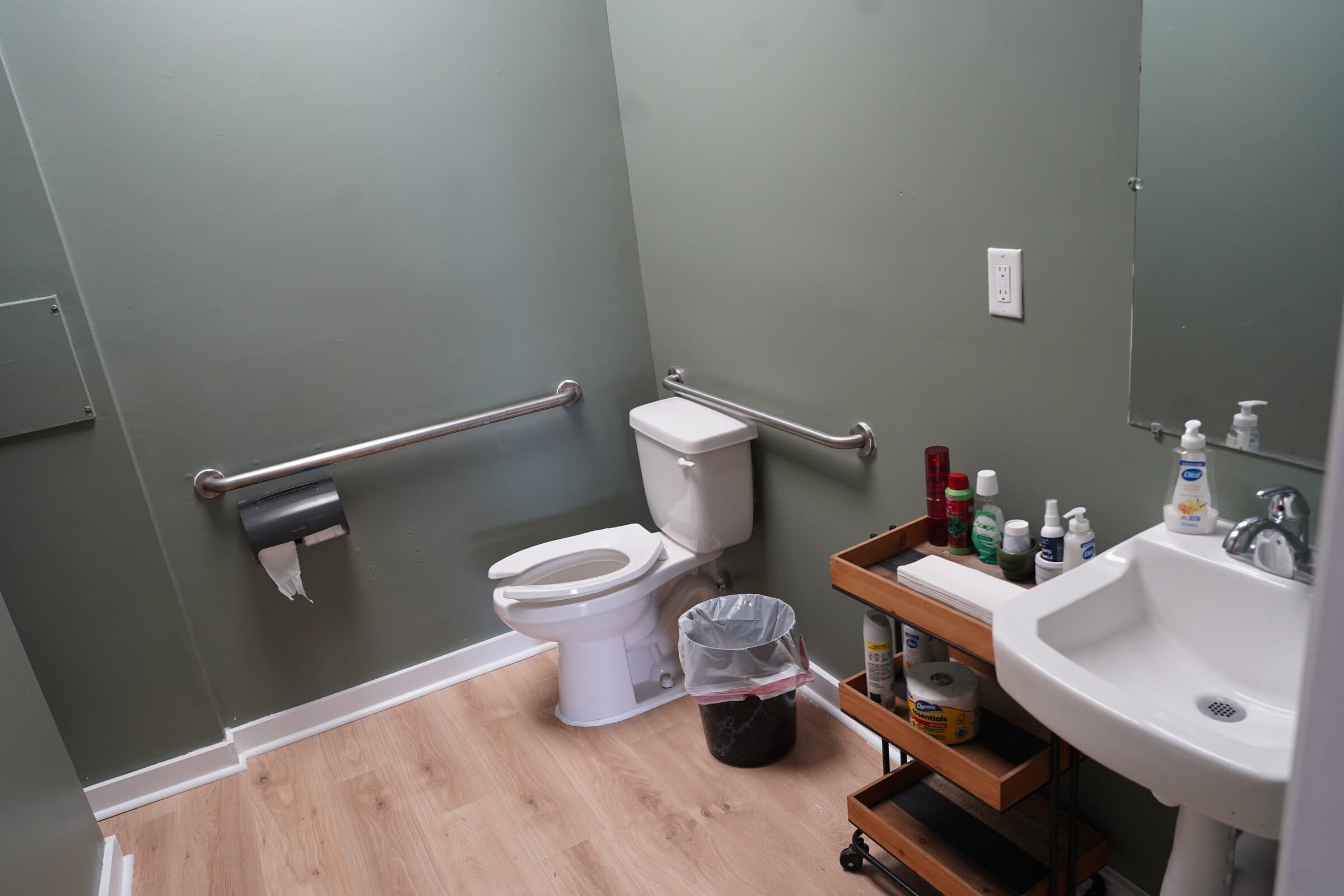 Accessible restroom with grab bars and a pedestal sink