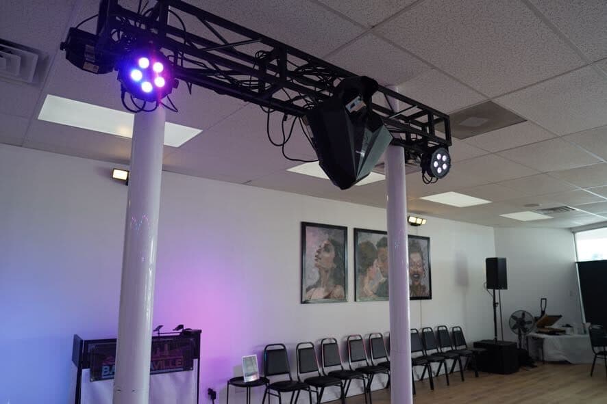 Close-up of the lighting truss with colored stage lights and a speaker